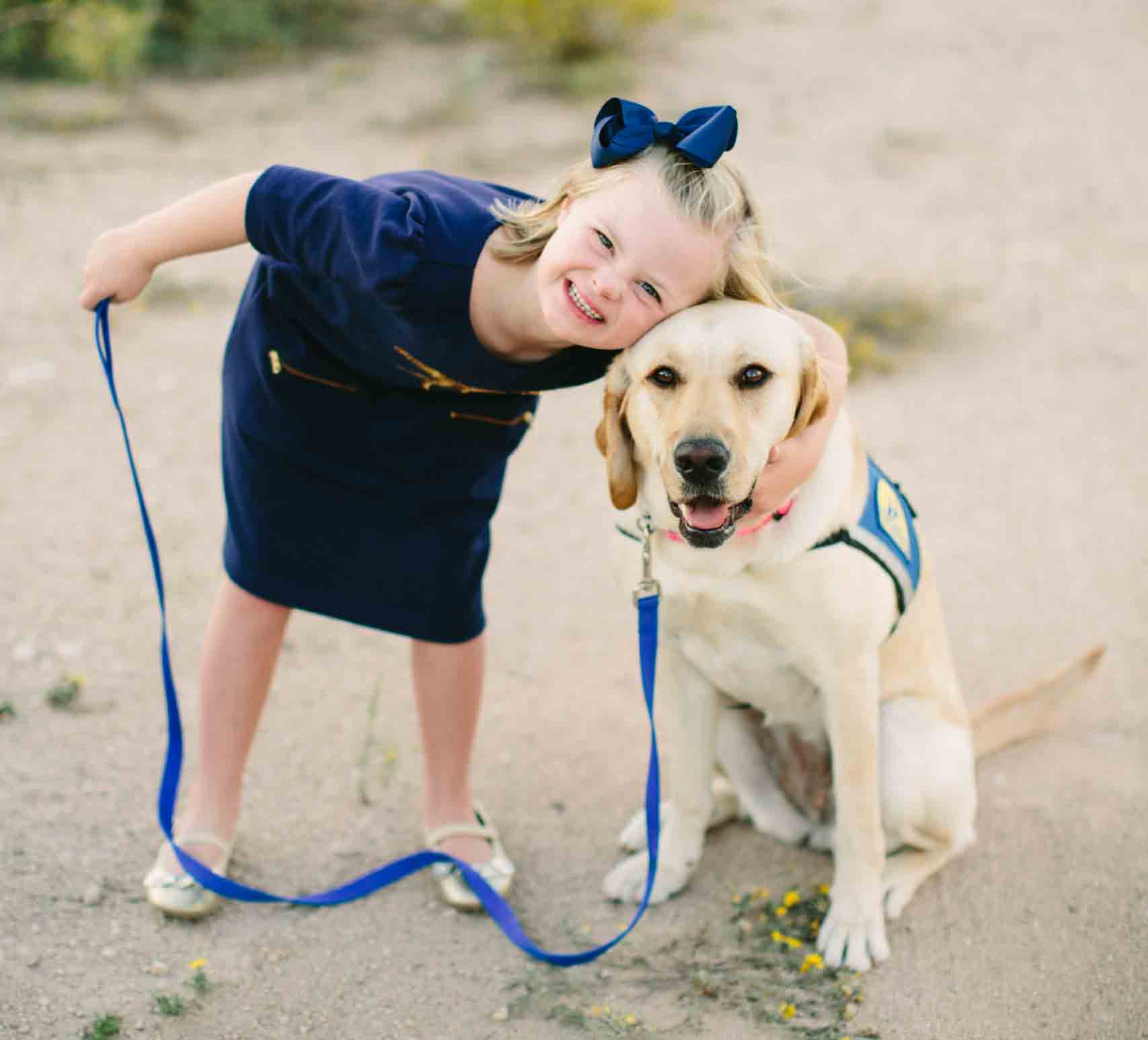 A girl standing beside her support dog